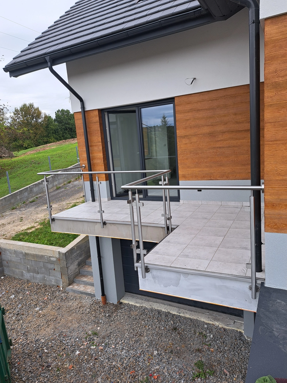 Balustrada balkonowa ze stali nierdzewnej na balkoniku z płytkami tarasowymi