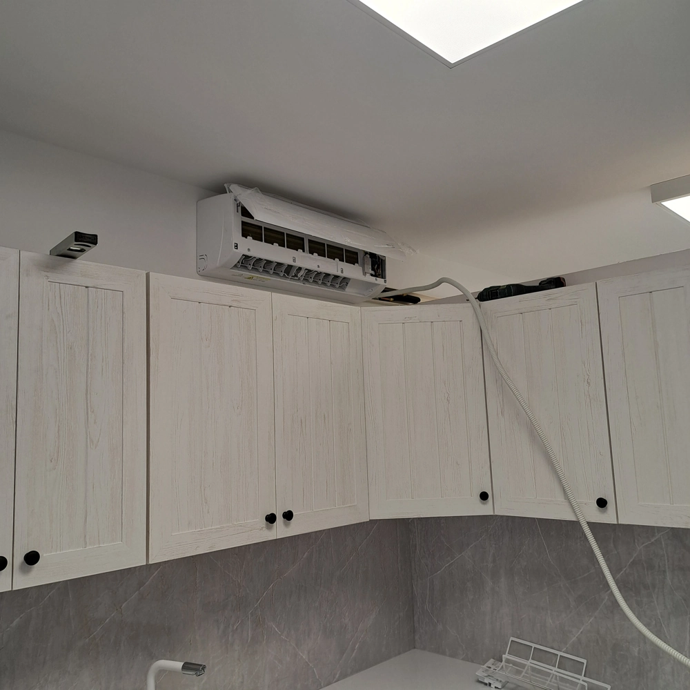 Jednostka klimatyzacji ściennej zamontowana nad szafkami kuchennymi