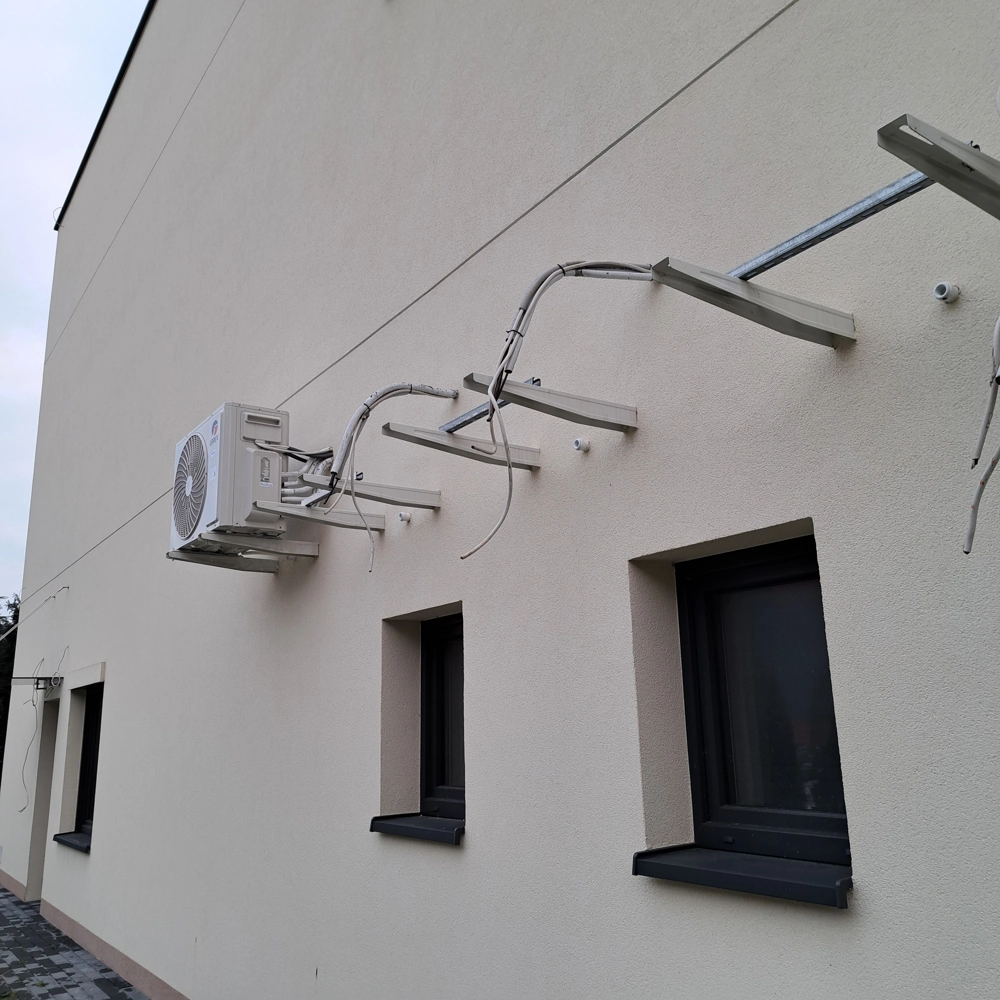 Zewnętrzna jednostka klimatyzacji zamocowana na uchwytach na ścianie budynku