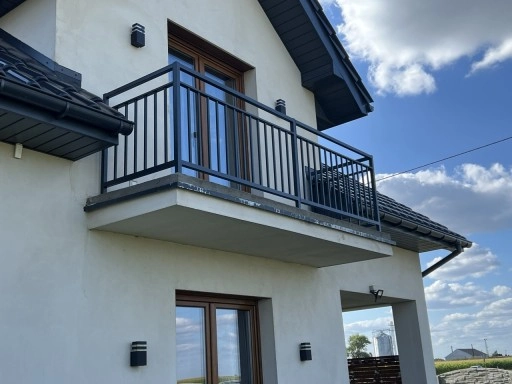 Metalowa balustrada balkonowa na nowoczesnej elewacji z zewnętrznym oświetleniem