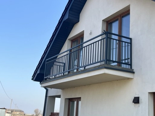 Balustrady balkonowe z czarnej stali zamontowane na elewacji nowego domu
